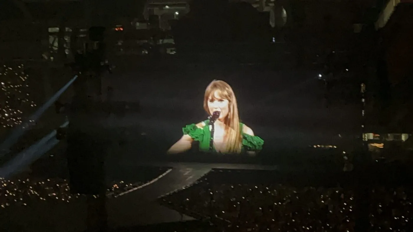 A singer lit up on a distant stage