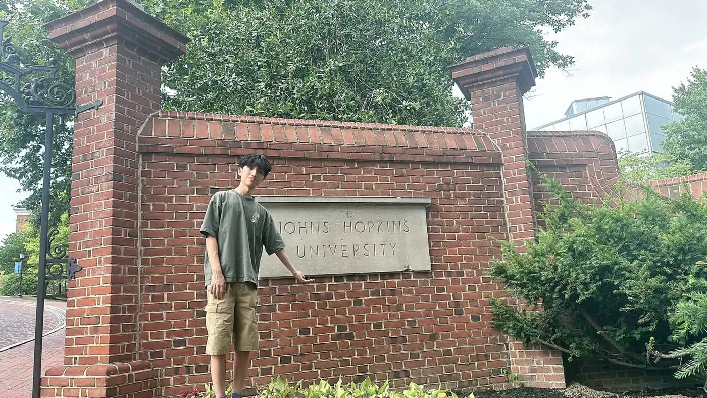 Standing at the Johns Hopkins University sign