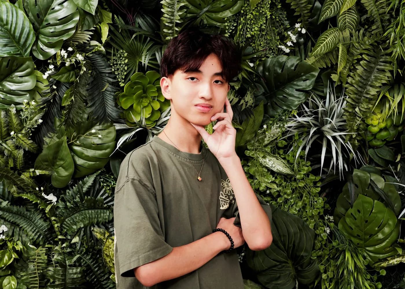 Portrait in front of a wall of greenery